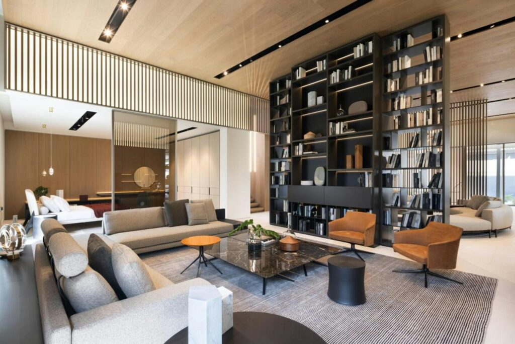 Modern living room with large bookshelf and comfortable seating.