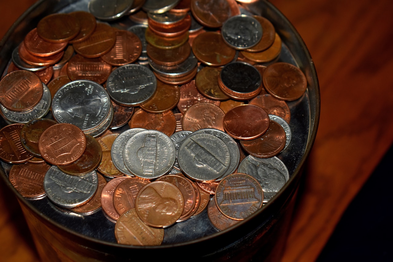 A close-up of a jar filled with pennies and nickels.