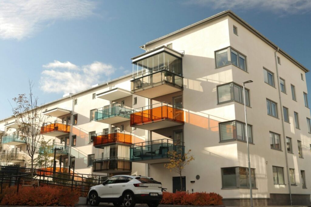 A modern apartment building in Jönköping, Sweden with stylish balconies and autumn foliage.